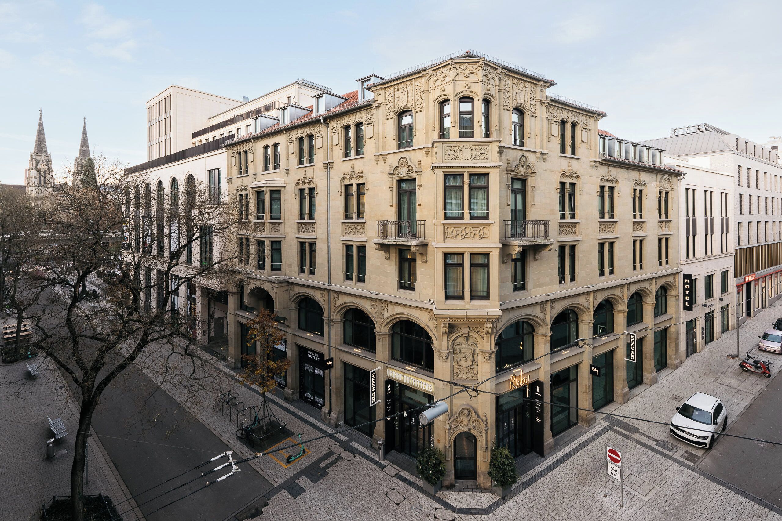 Un edificio de esquina de estilo arquitectónico clásico, con ventanas arqueadas y una entrada destacada.