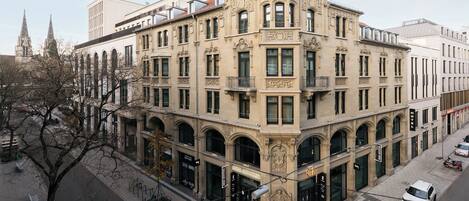 Un edificio de esquina de estilo arquitectónico clásico, con ventanas arqueadas y una entrada destacada.