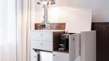 Un mini-bar moderne et compact, doté d’une lampe, d’une machine à café et d’un réfrigérateur à vin.