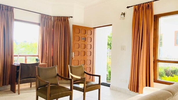 Una habitación amplia con un ventanal grande, una puerta de madera y un sofá.