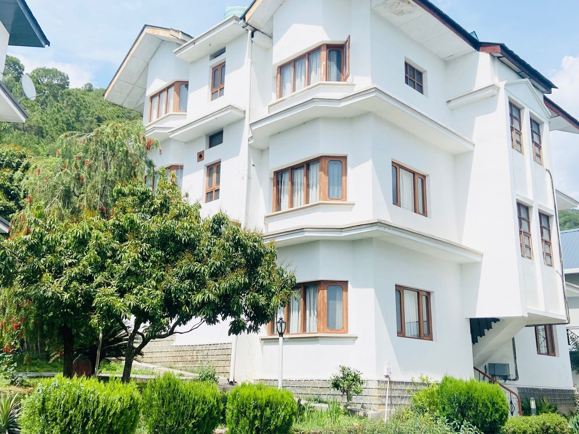 Un edificio blanco de varios pisos con múltiples ventanas y balcones.