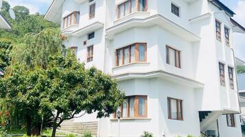 Un edificio blanco de varios pisos con múltiples ventanas y balcones.