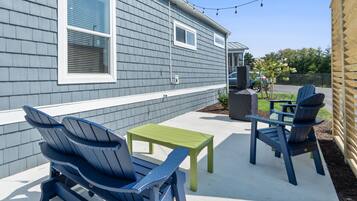 A house with a covered patio area featuring outdoor furniture.