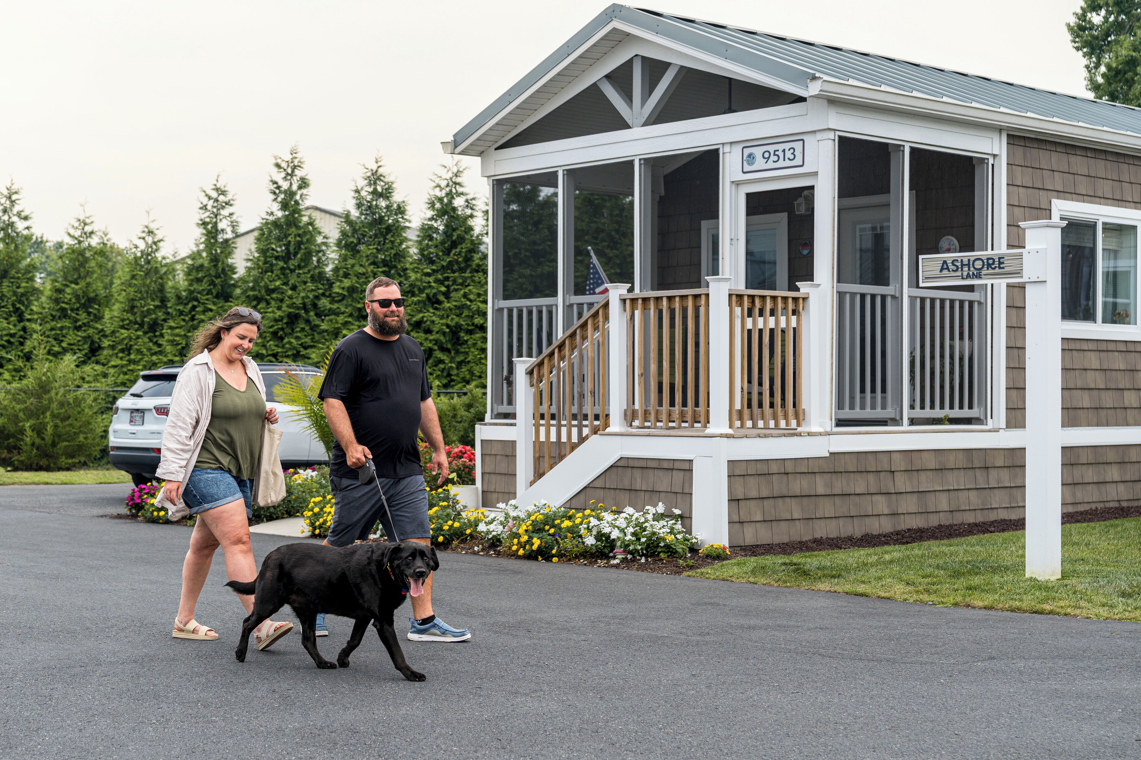 A covered outdoor area with a wooden deck, a porch, and a small building with a sign reading "ASHORE LANE."