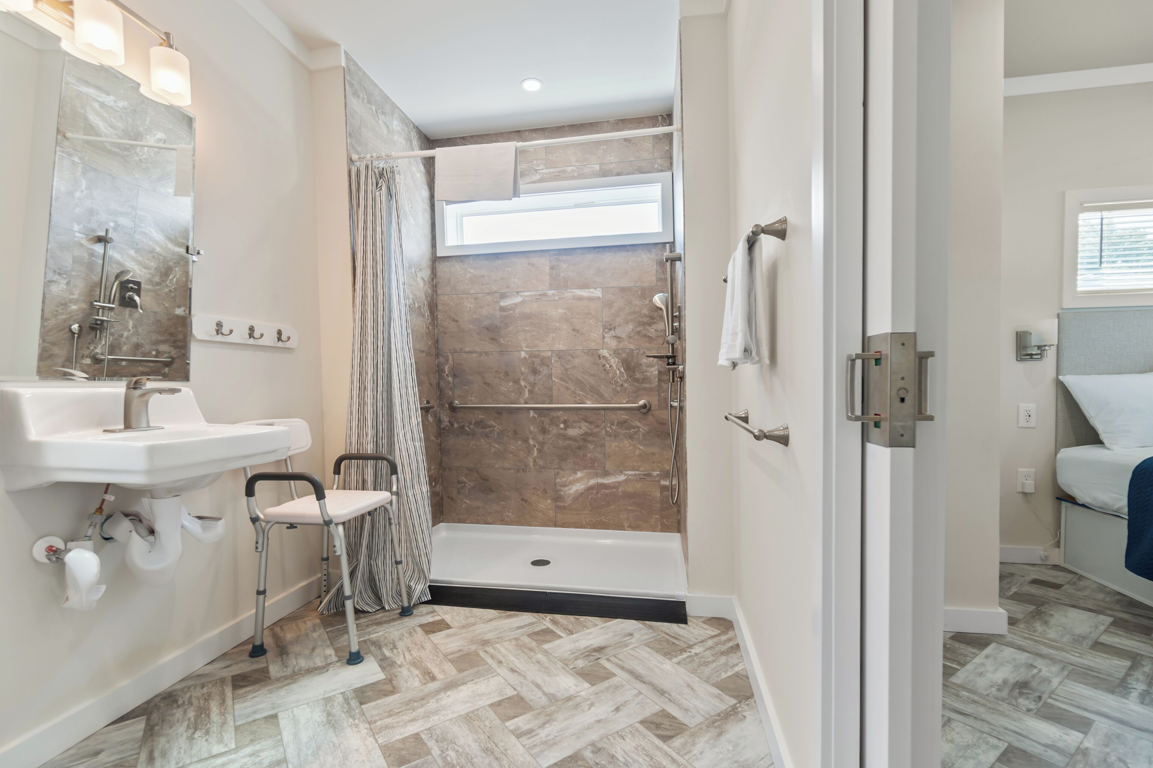 A modern bathroom with a shower, a sink, and a toilet.