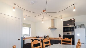 Une cuisine compacte comprenant une table à manger, des chaises et des appareils électroménagers modernes.