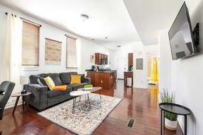 A modern living room with a grey sofa, a coffee table, and a patterned rug.
