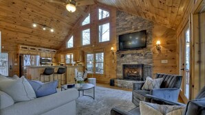 A cozy cabin interior with a living area, kitchen, and fireplace. - Sharin-A-Lakeview | $229 Off Your Stay! (Blue Ridge)