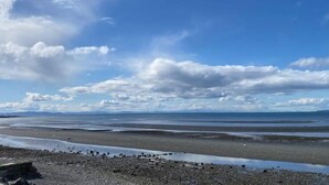 A coastal landscape with a pebbly beach, calm sea, and a clear sky. - Hop off the steps onto the beach - a rare Birch Bay Find!  Kayaks, full kitchen. (Blaine)