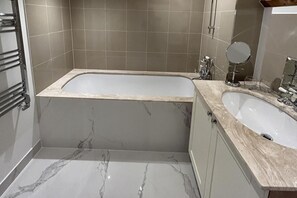 A bathroom with a freestanding bathtub, a sink, and a mirror. - No Longer Available (Petworth)