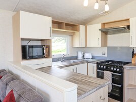 A compact kitchen with a microwave, toaster, sink, stove, and oven.