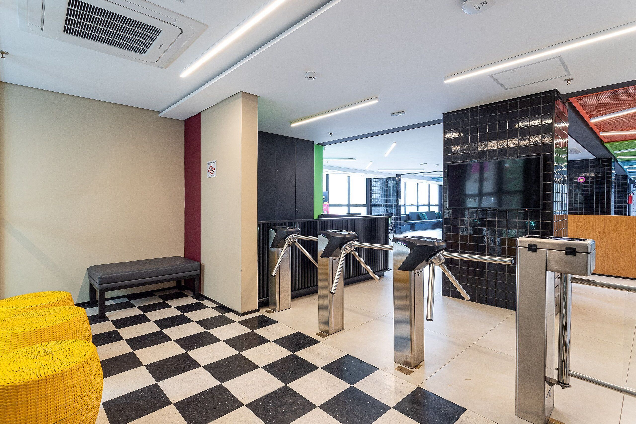 A check-in area with a check-in counter, turnstiles, a bench, and a check-in desk.