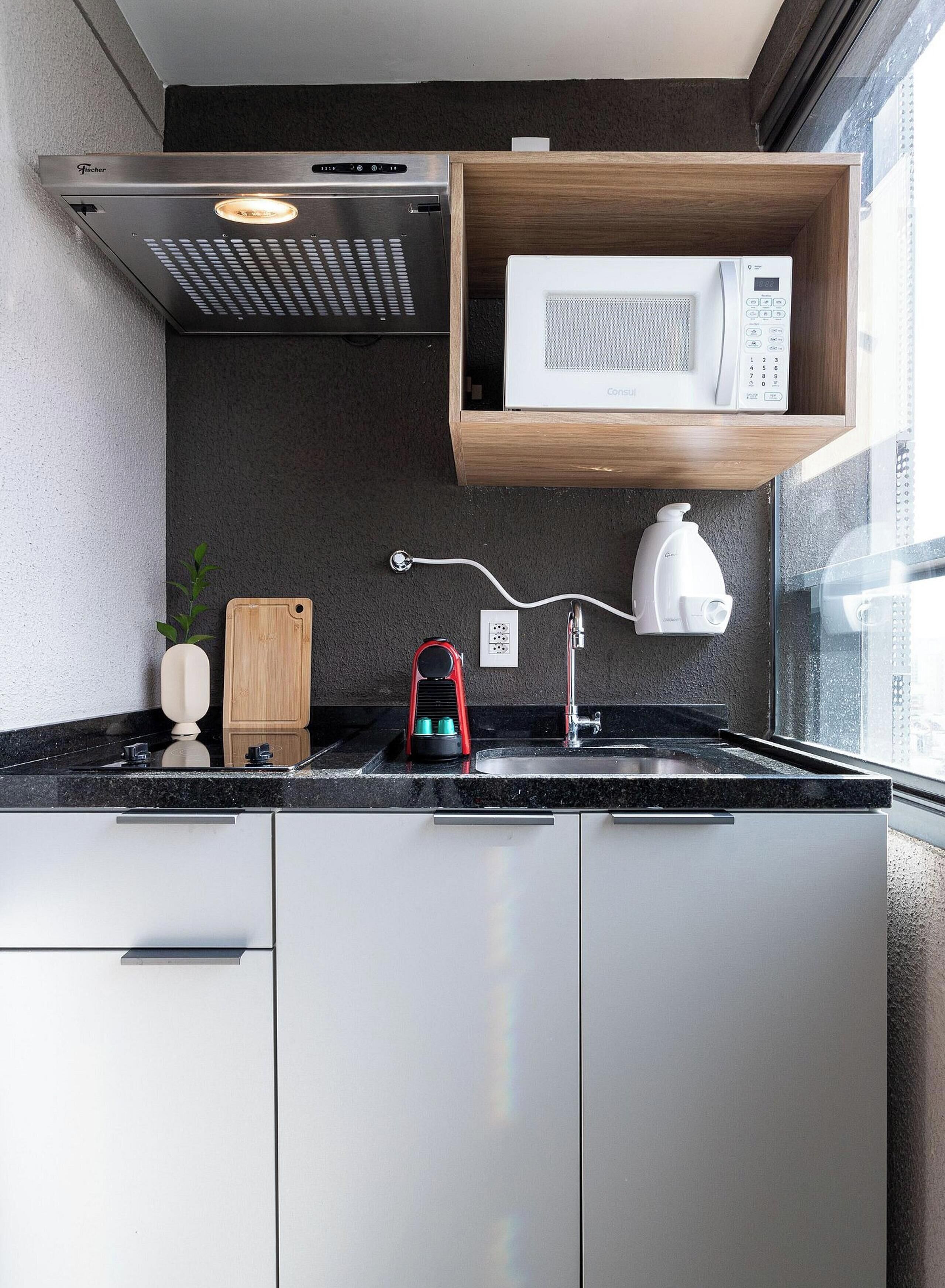 A modern kitchen with a built-in microwave, a coffee machine, and a gas stove.