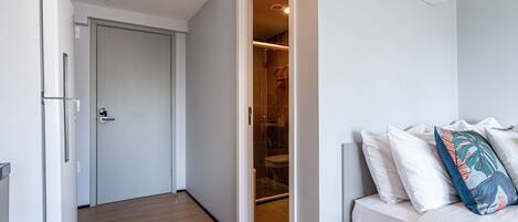A modern bedroom with a bed, pillows, and an air conditioning unit.