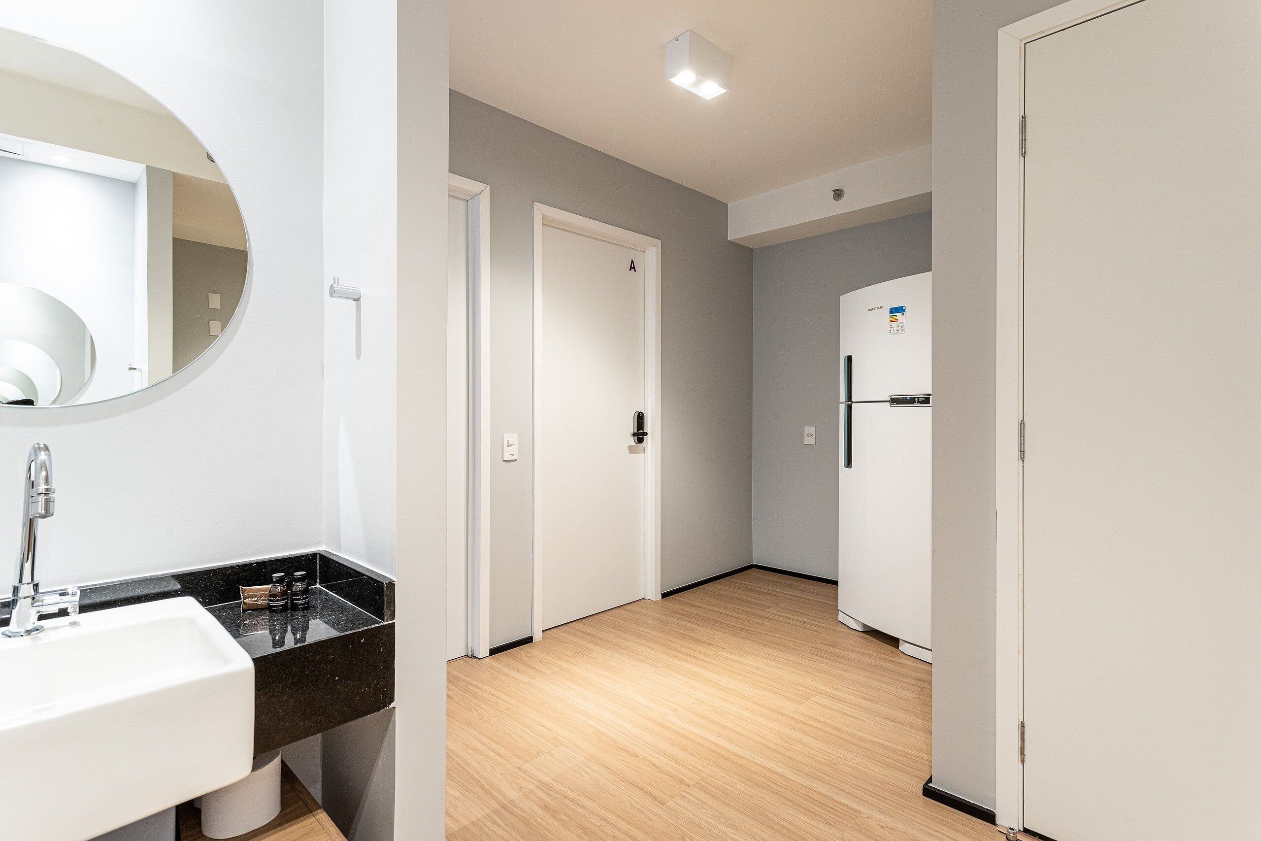 Et moderne badeværelse med håndvask, spejl og toilet.