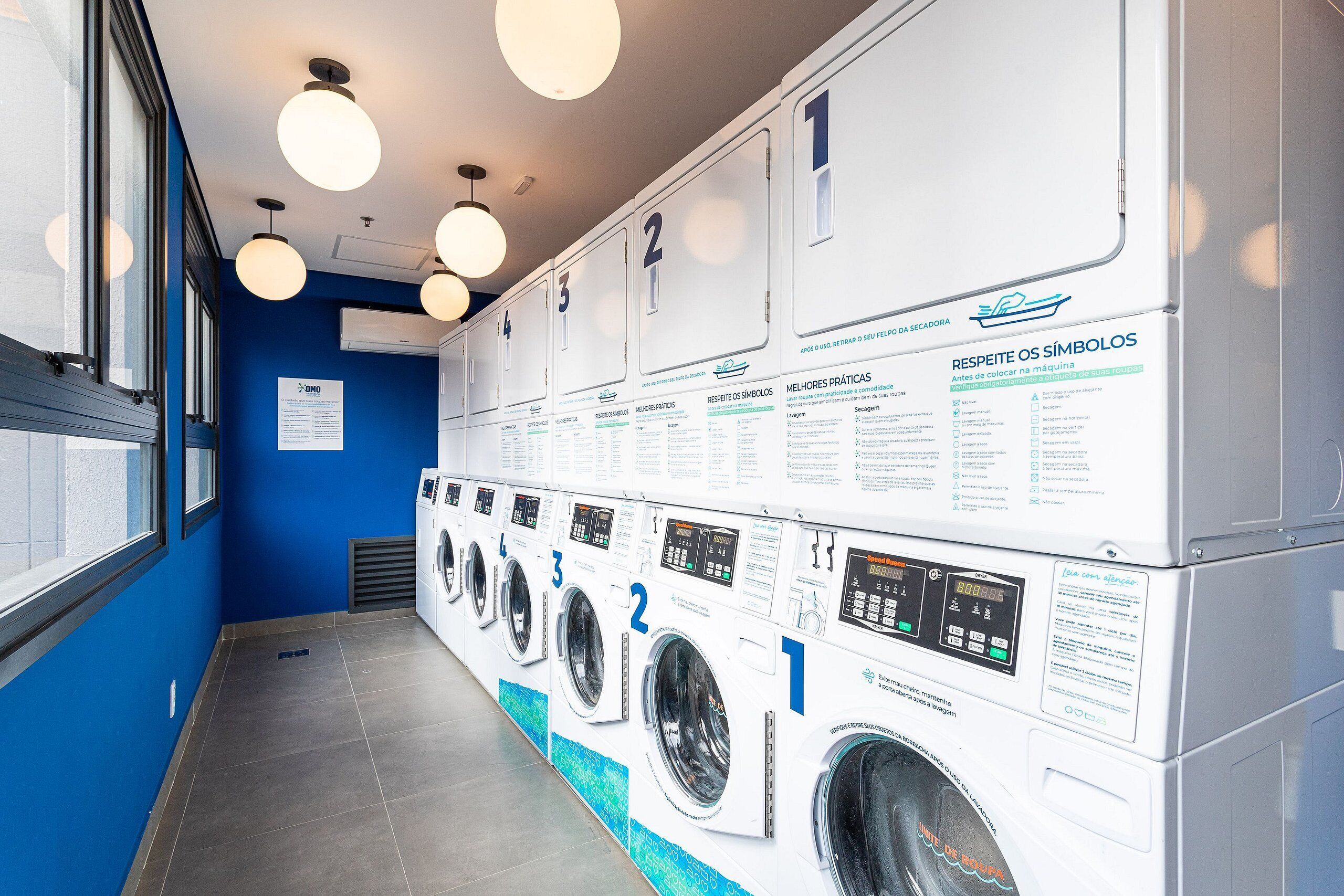 A laundry facility with numbered washing machines and instructional signs.