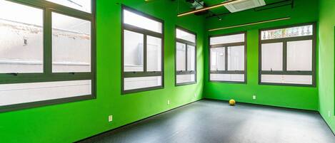 A room with green walls, large windows, and a black floor.