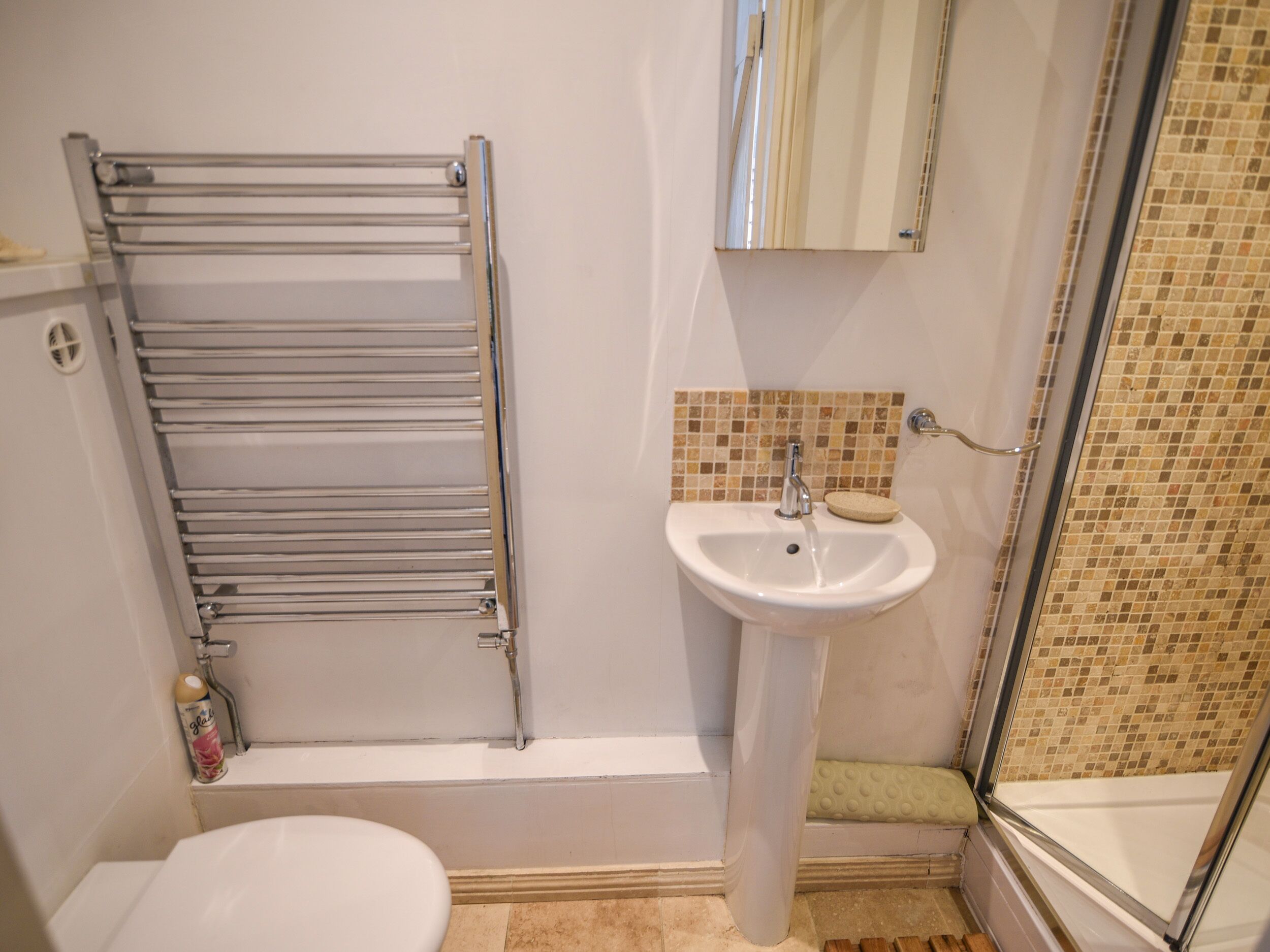 A bathroom with a toilet, sink, and shower.