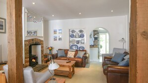 A cozy living room with a fireplace, leather sofas, and a coffee table. - 21 Mill Green (Lyme Regis)