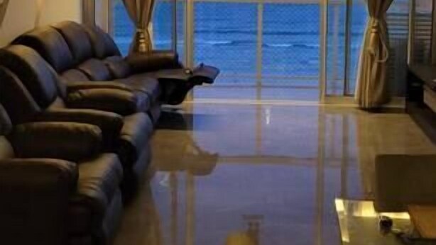 A modern living room with a large window, a sofa, and a coffee table. - Apartamento Guarujá (Guarujá)