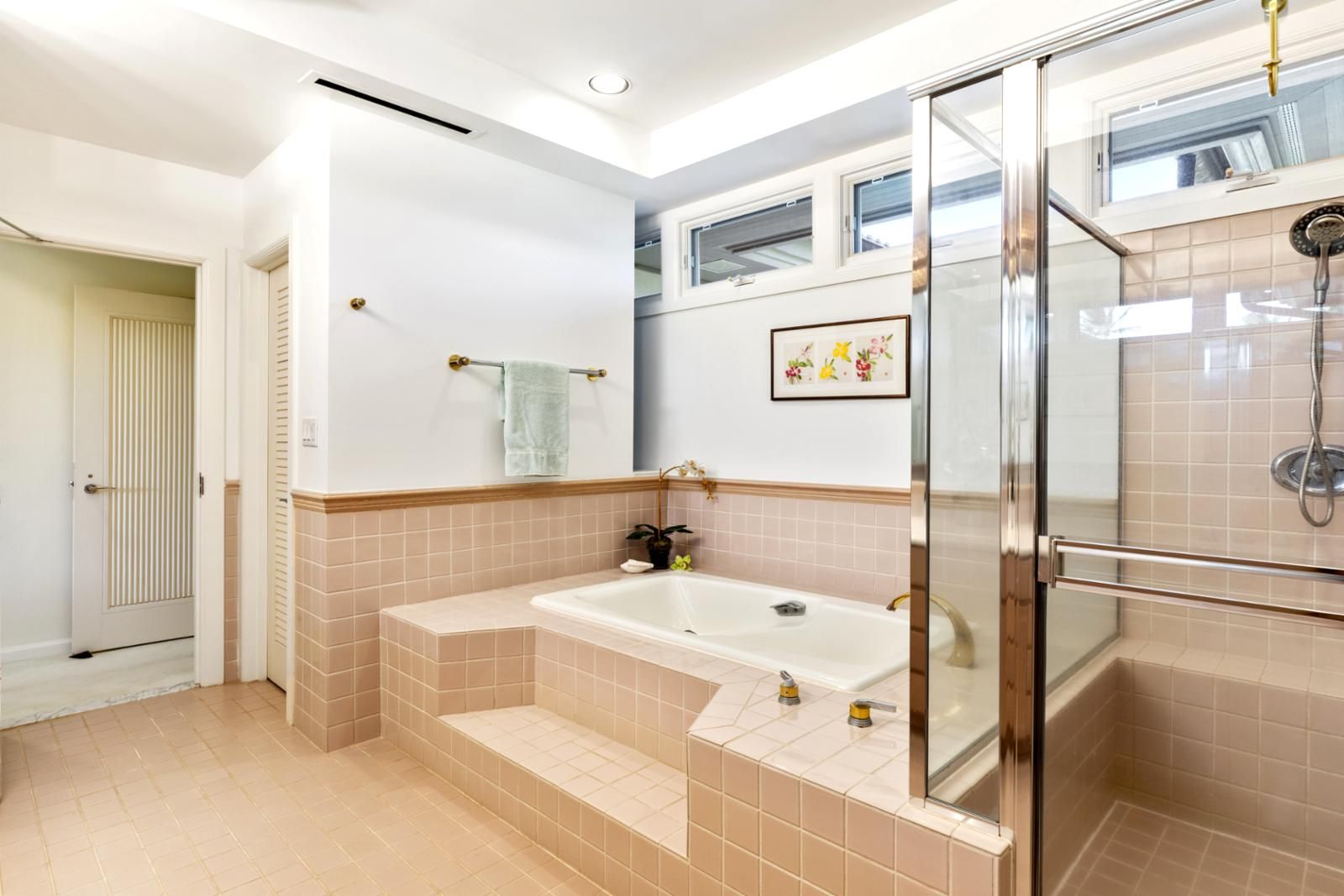 A modern bathroom with a glass shower enclosure, a freestanding bathtub, and a small sink.