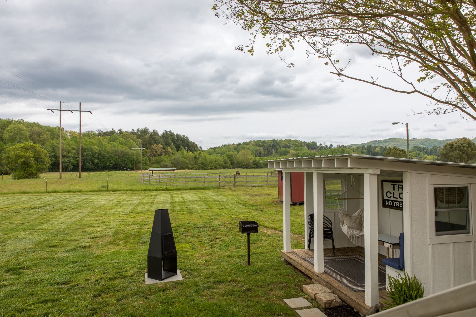 A small, single-story building with a porch and a covered outdoor seating area.