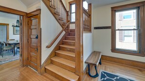 A wooden staircase with a handrail, a bench, and a large window. - Spacious Historic Home in the Berkshires! (Pittsfield)