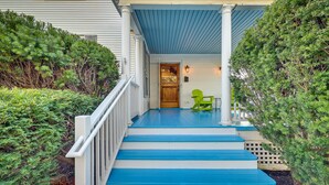 A porch with blue steps, a wooden door, and a green chair. - Spacious Historic Home in the Berkshires! (Pittsfield)