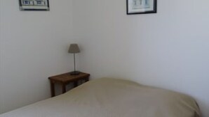 Et soveværelse med en seng, et natbord og en lampe.
