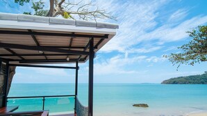 Un área de estar al aire libre cubierta con vista al océano y a la playa.