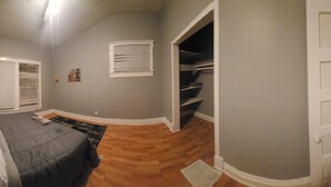 A bedroom with a bed, a window with blinds, a door leading to a closet, and a hallway. - Derby rental furnished 2BR, 1 full bath(shower/tub) house (Louisville)