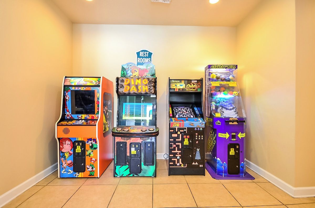 Cuatro máquinas recreativas en un pasillo.