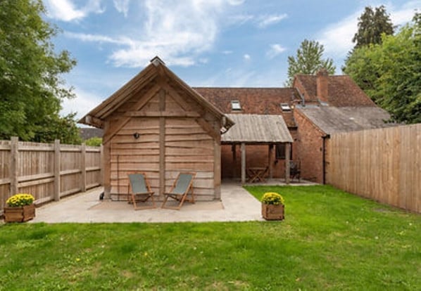 Relax in a peaceful outdoor setting with a covered seating area and wooden fence.