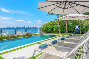 A pool area with lounge chairs and an umbrella, a view of the city skyline, and a target sign.
