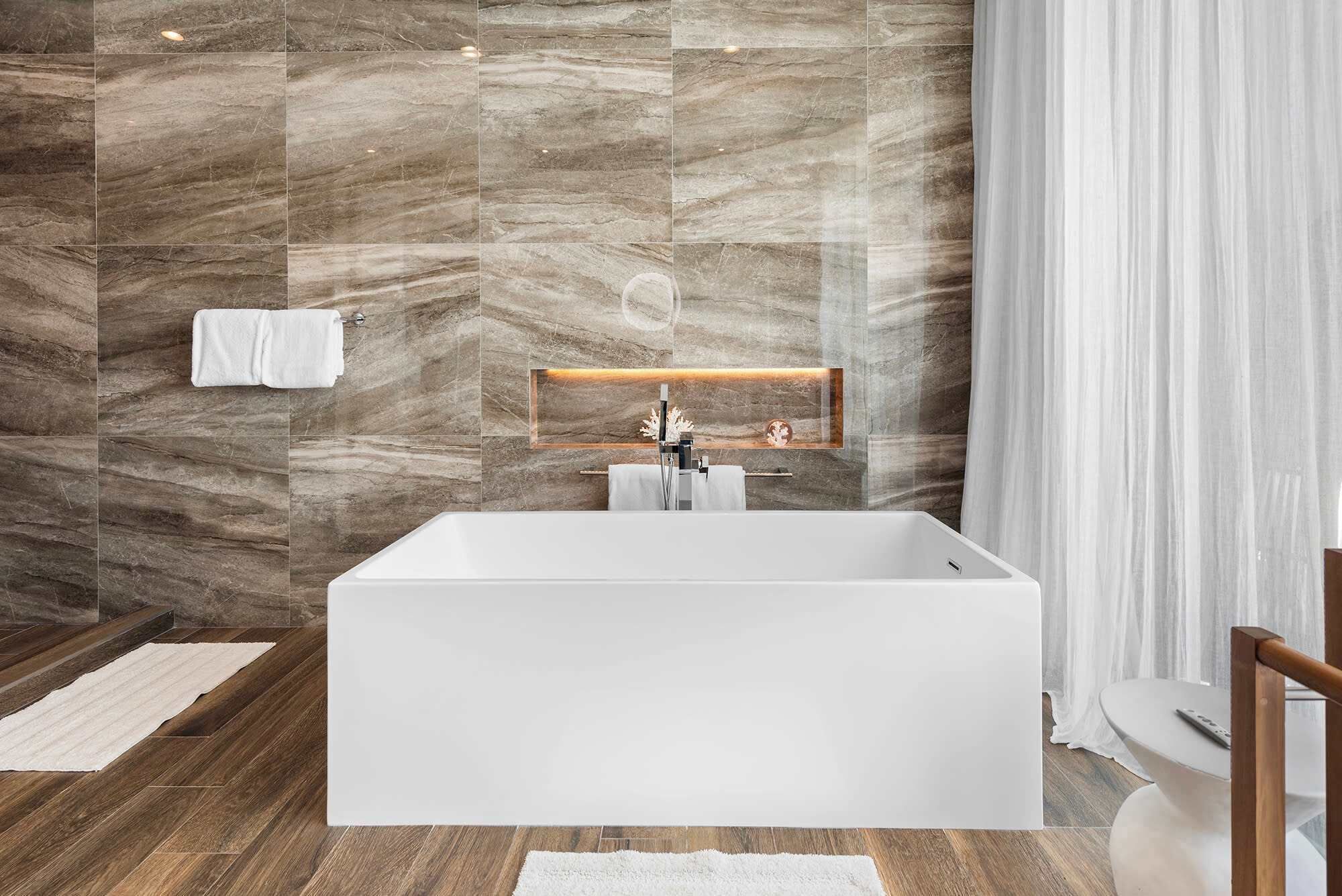 Une salle de bain moderne avec une grande baignoire, des murs en marbre et un plancher en bois.
