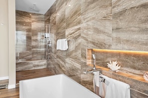 A modern bathroom with a shower, a bathtub, and a vanity with a mirror. - Luxury Bayfront Villa with Pool New Construction (North Bay Village)