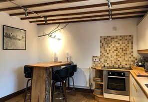 Enjoy cooking in this well-equipped kitchen with an oven, tiled backsplash, and radiator.