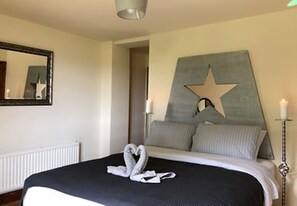 Cozy retreat with a neatly made bed, star-shaped wall decoration, and a bedside table.