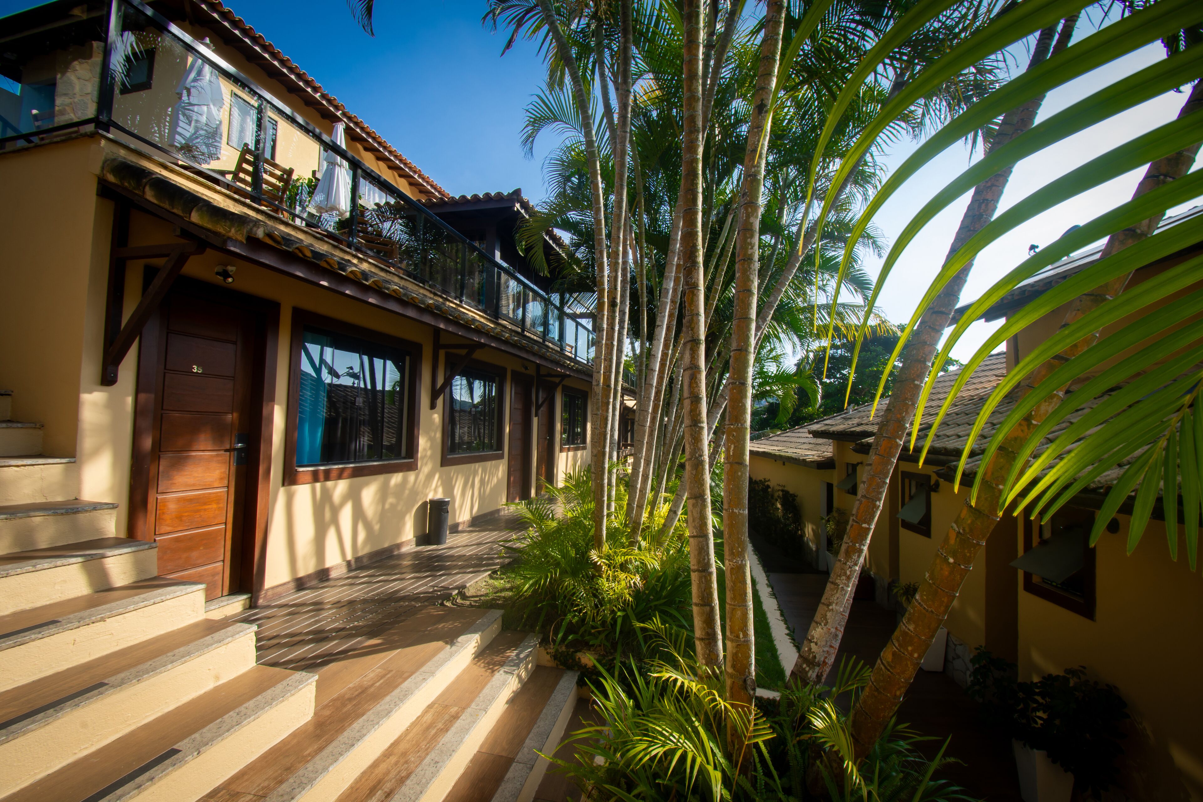 A two-story building with a balcony, a wooden door, and a tiled roof.