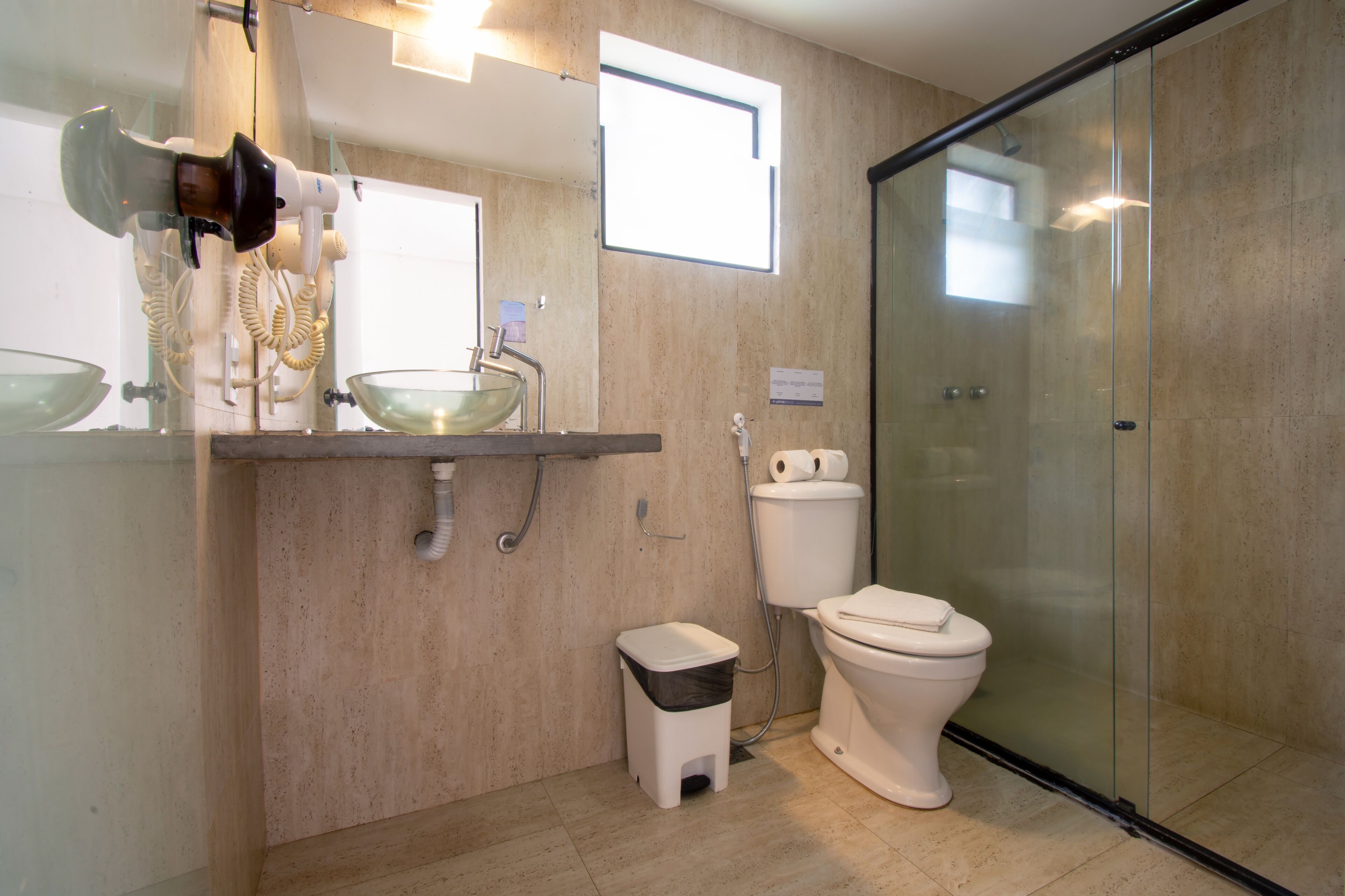 Une salle de bain moderne avec une douche à parois de verre, des toilettes blanches et un lavabo en verre.
