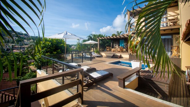 A rooftop terrace with lounge chairs, a pool, and a view of the surrounding landscape. - Hotel Barra da Lagoa by Latitud Hoteles (Búzios)