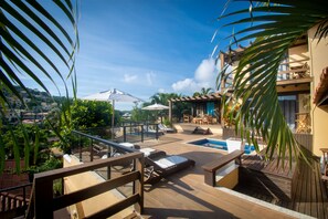 A rooftop terrace with lounge chairs, a pool, and a view of the surrounding landscape. - Hotel Barra da Lagoa by Latitud Hoteles (Búzios)