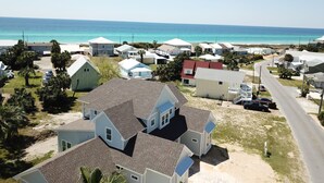 A coastal residential area with houses and a beach in the background.