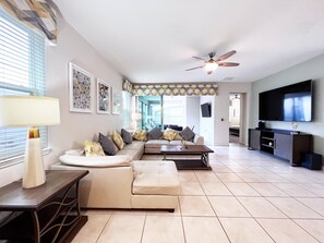 Relax in this stylish living room with a comfortable sofa, flat-screen TV, and floor lamp.