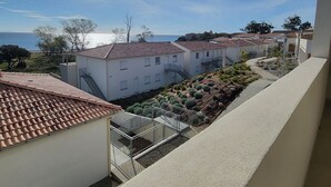 A residential area with terracotta-tiled roofs, a clear sky, and a view of the sea. - Le Paradis à la Plage (Linguizzetta)