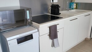 A compact kitchen with a microwave, coffee maker, and a small sink. - Le Paradis à la Plage (Linguizzetta)
