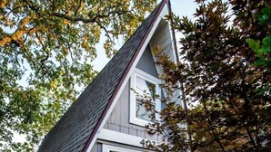 Une maison de plain-pied avec un toit à pignon, un porche à l’avant et le numéro « 402 » bien visible.