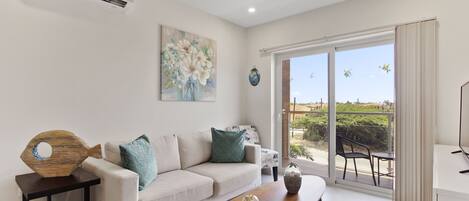 A modern living room with a sofa, coffee table, and artwork on the wall.