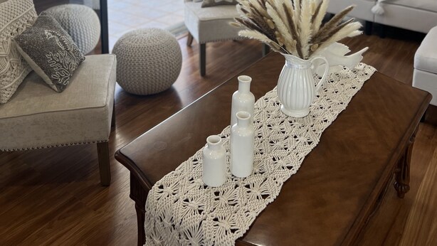 A modern living room with a wooden coffee table, white sofas, and a view of the outdoors. - Dock Beach House in Sombrero Beach (Marathon)