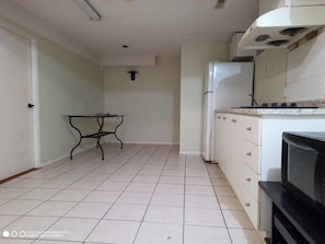 Réfrigérateur, un four, surface de cuisson, vaisselle et ustensiles